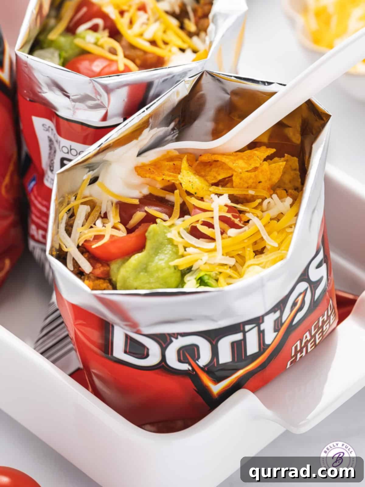 Walking Tacos feature all of your favorite taco ingredients and toppings in a personal-sized bag of chips. Quick and easy to prepare! Close up of a taco in a bag
