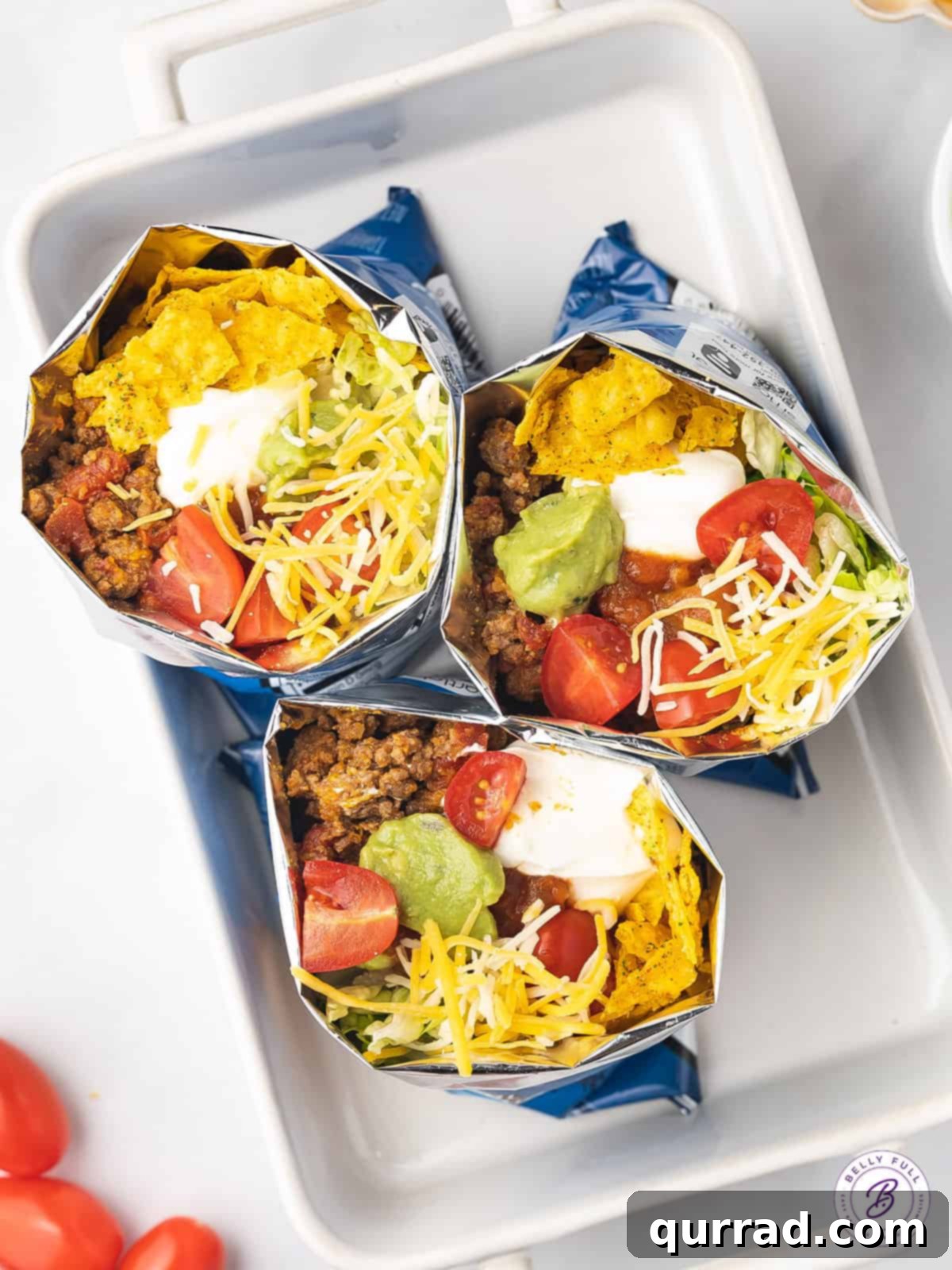 Walking Tacos feature all of your favorite taco ingredients and toppings in a personal-sized bag of chips. Quick and easy to prepare! Overhead view of walking tacos in Dorito bags