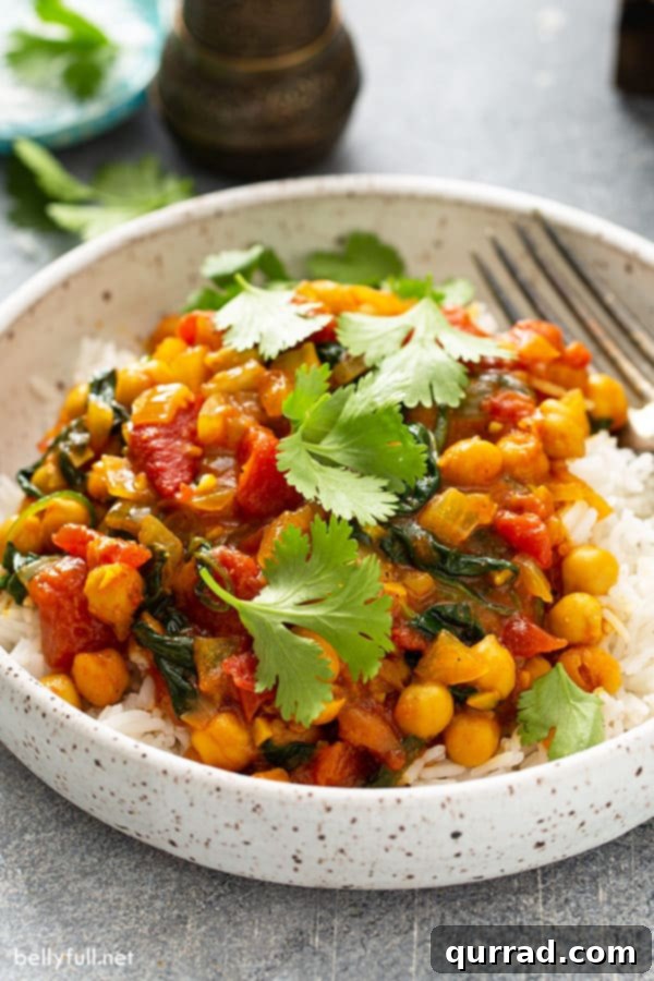 Your New Favorite Chickpea Curry 8 Close-up of chickpeas in a creamy curry tomato sauce over cooked white rice, ready to be served.