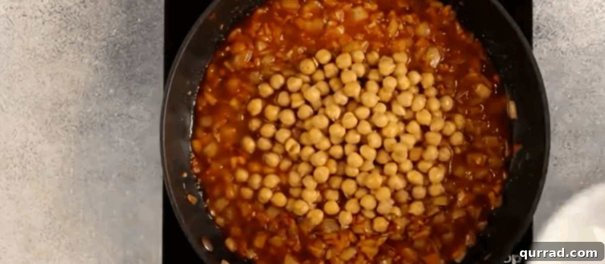 Your New Favorite Chickpea Curry 5 Adding chickpeas, tomatoes, and broth to the skillet with cooked aromatics.