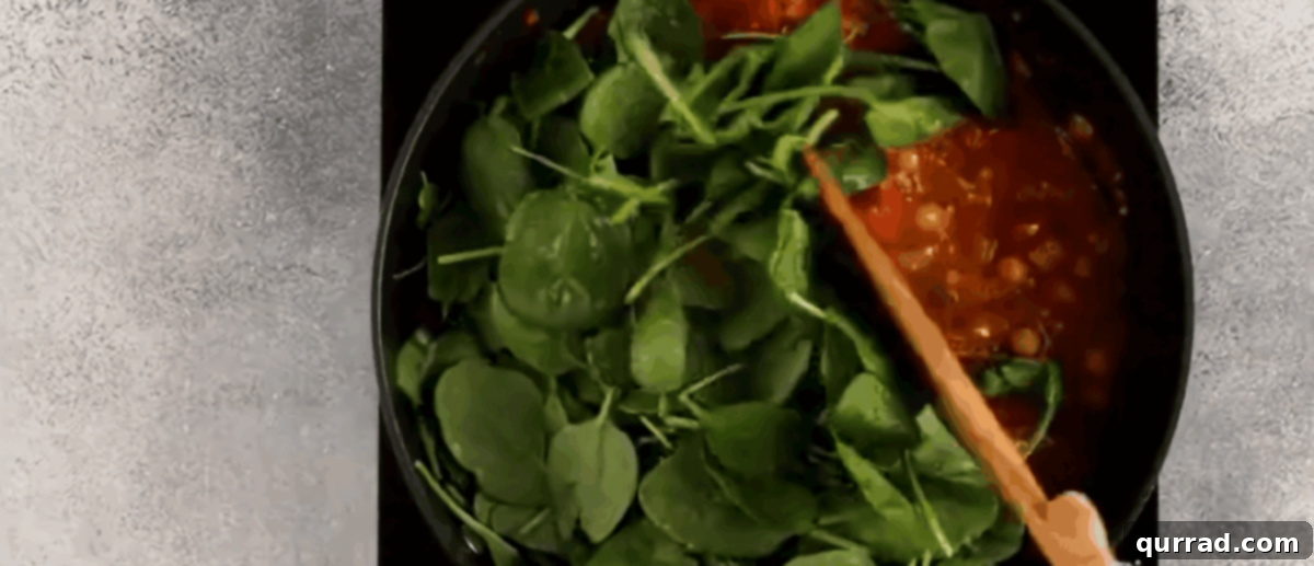 Your New Favorite Chickpea Curry 6 Stirring fresh spinach into the chickpea curry until wilted.