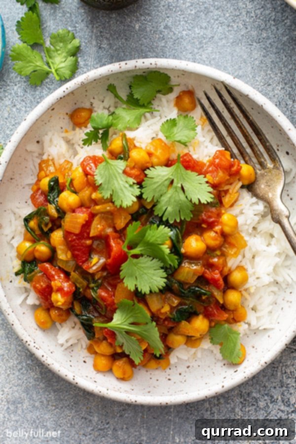 Your New Favorite Chickpea Curry 7 Garbanzo beans in a creamy curry tomato sauce served over cooked white rice in a bowl.