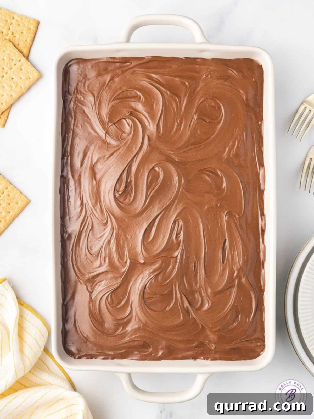 This Chocolate Eclair Dessert tastes like the best combination of Boston cream pie and a chocolate eclair. Just 5 ingredients! A full 9x13 baking dish of the assembled Chocolate Eclair Cake, ready for its final chill, showing layers before the chocolate topping is added.