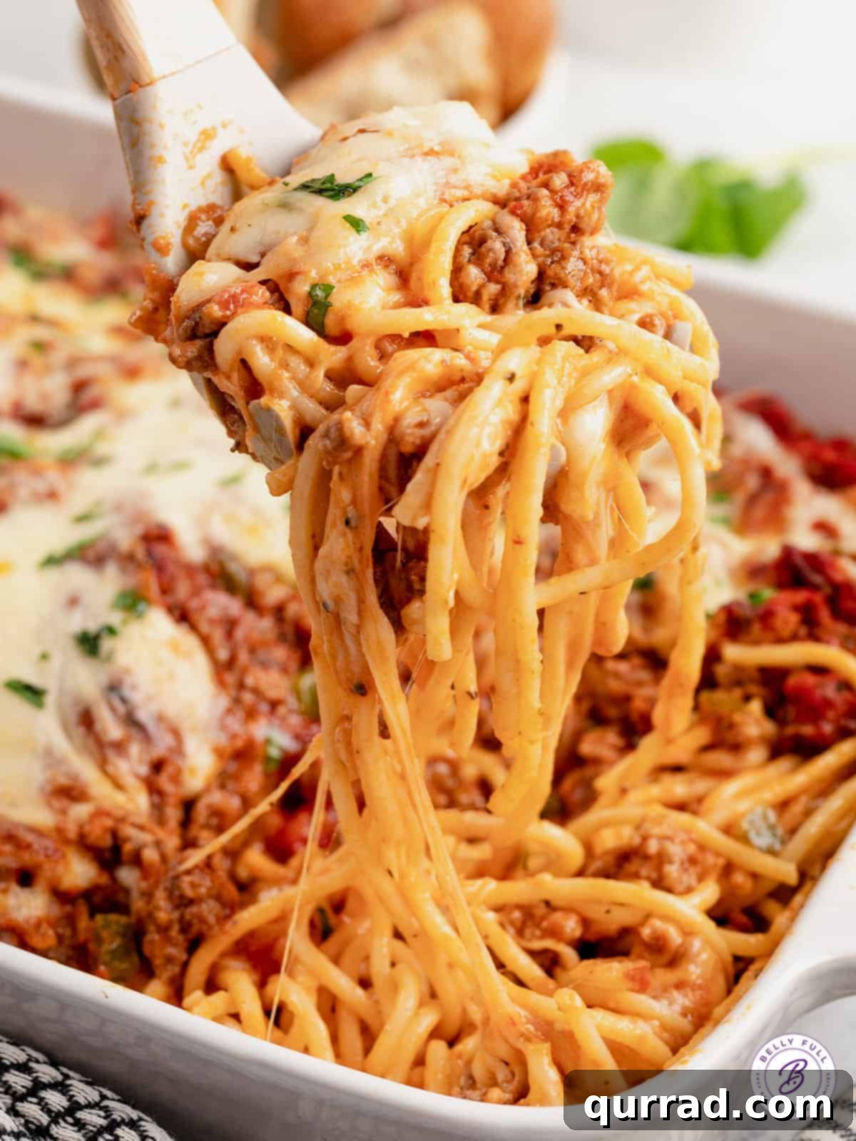 Made with spaghetti, marinara meat sauce, and homemade alfredo sauce, this Million Dollar Spaghetti Alfredo is an easy weeknight dinner. A forkful of million dollar spaghetti, showcasing the layers of pasta, meat sauce, alfredo, and melted cheese