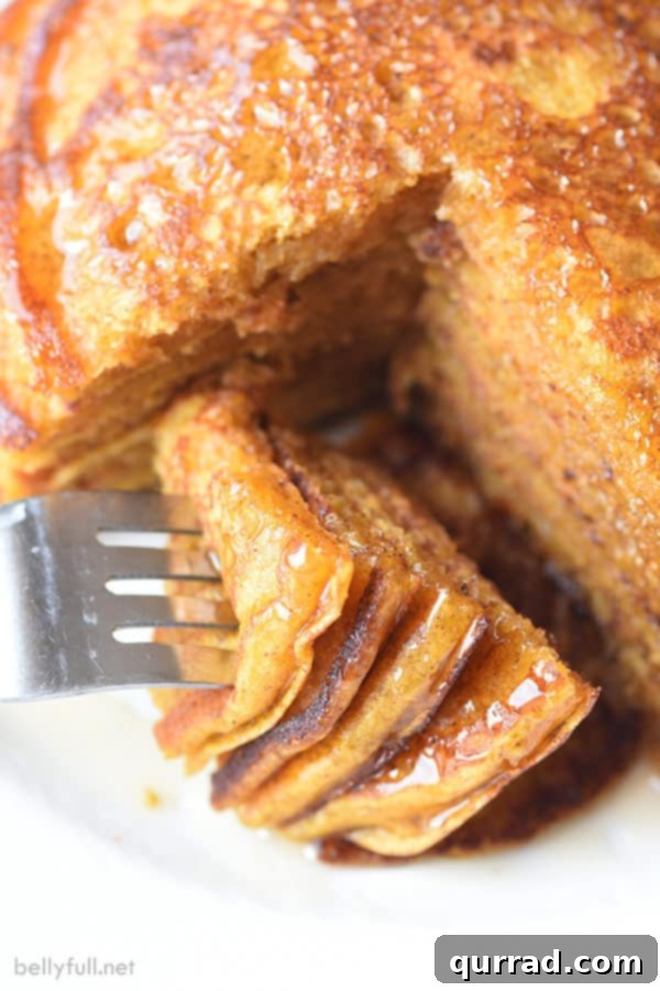 Harvest Pumpkin Griddlecakes 2 sliced pumpkin pancakes on fork with syrup