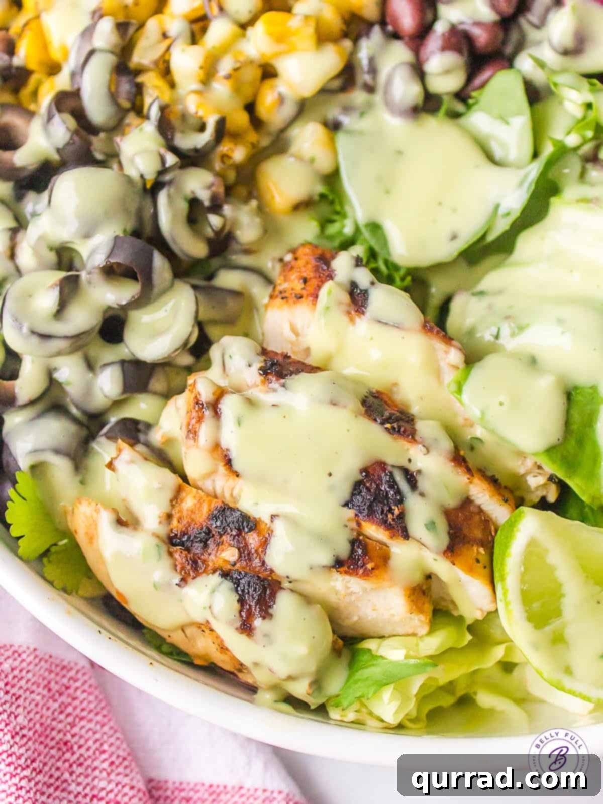 With well-seasoned grilled chicken, grilled corn, black olives, and tomatoes, this Southwest Chicken Salad is bursting with color and flavor. Close up of southwest grilled chicken salad with avocado cilantro dressing