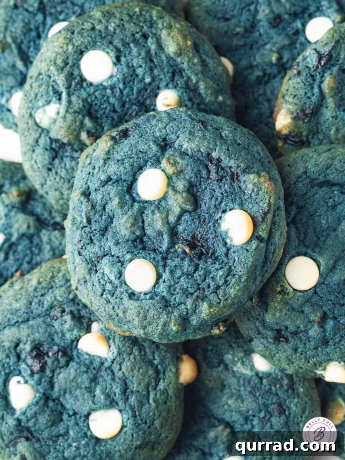 Blueberry Bliss Cheesecake Cookies 3 Overhead view of a pile of freshly baked blueberry cheesecake cookies, liberally studded with bright blueberries and white chocolate chips.