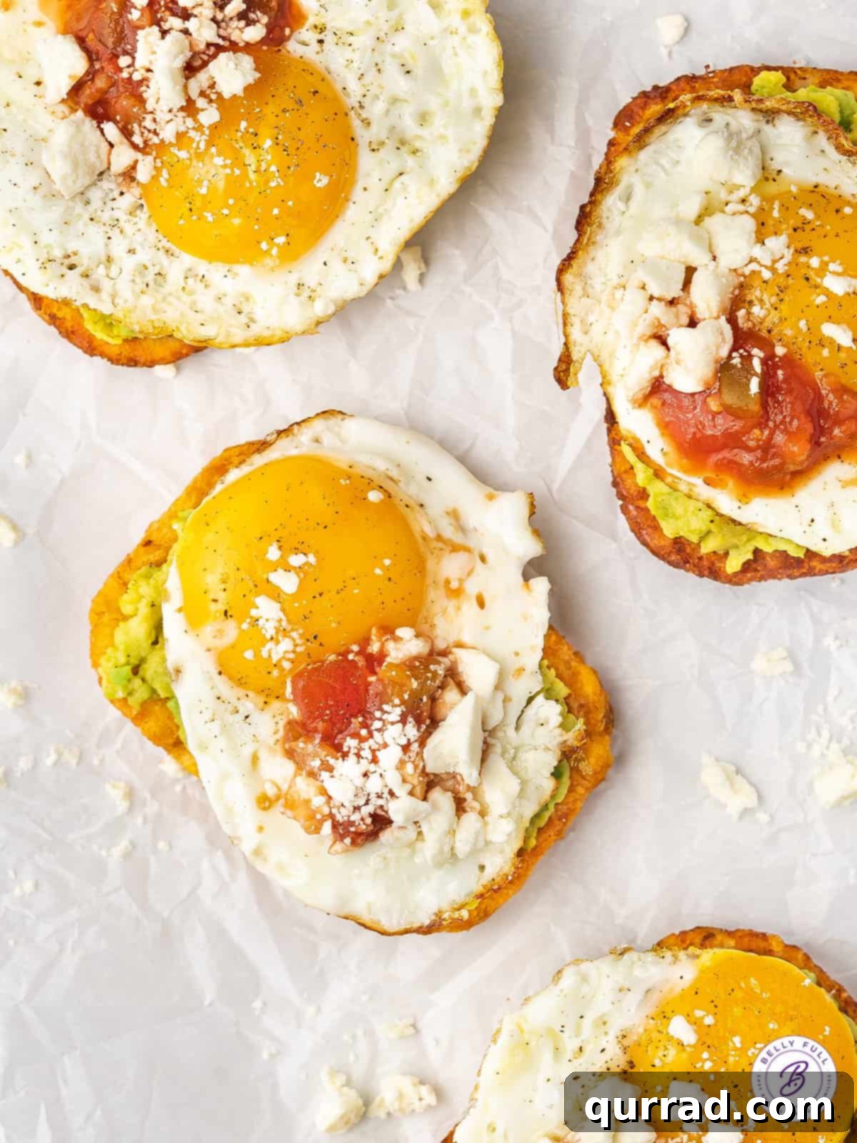 Stacked Hash Brown Avocado Toasts with runny egg yolk and fresh toppings