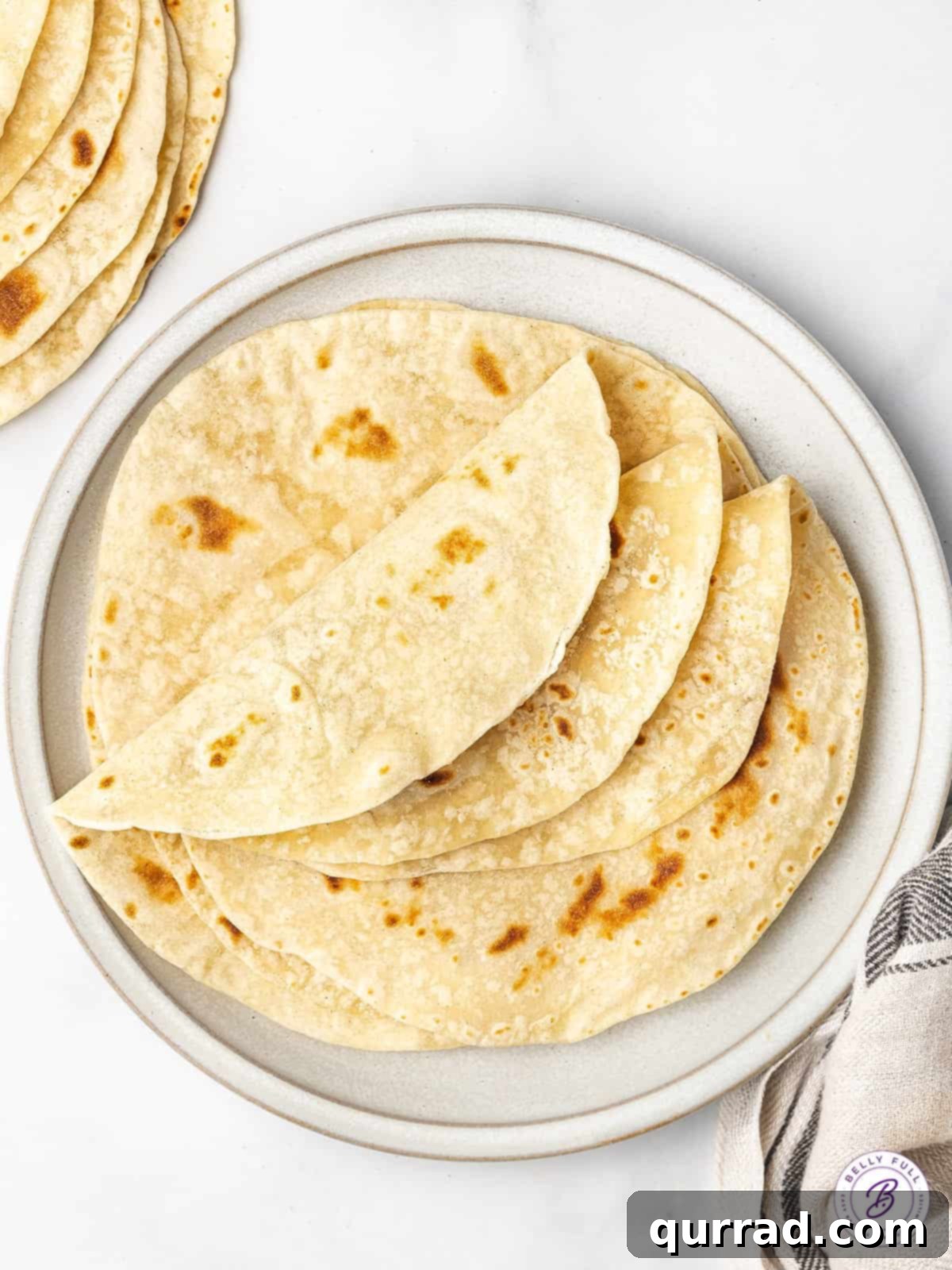 Folded flour tortillas artfully arranged on a rustic plate, ready to be served with your favorite Mexican dishes.