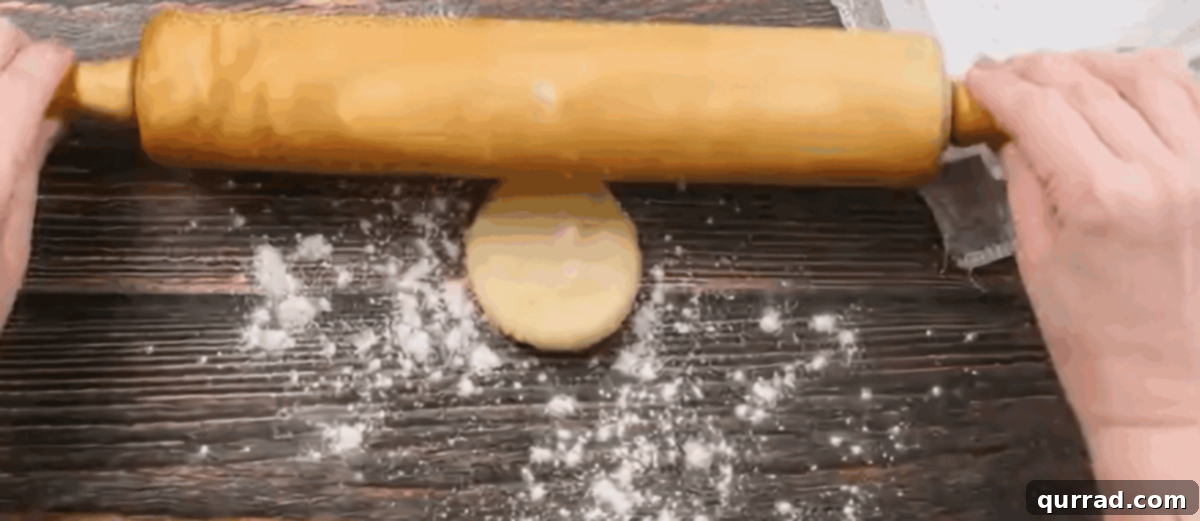 A rolling pin skillfully rolling out a dough ball into a thin, round tortilla on a lightly floured surface.