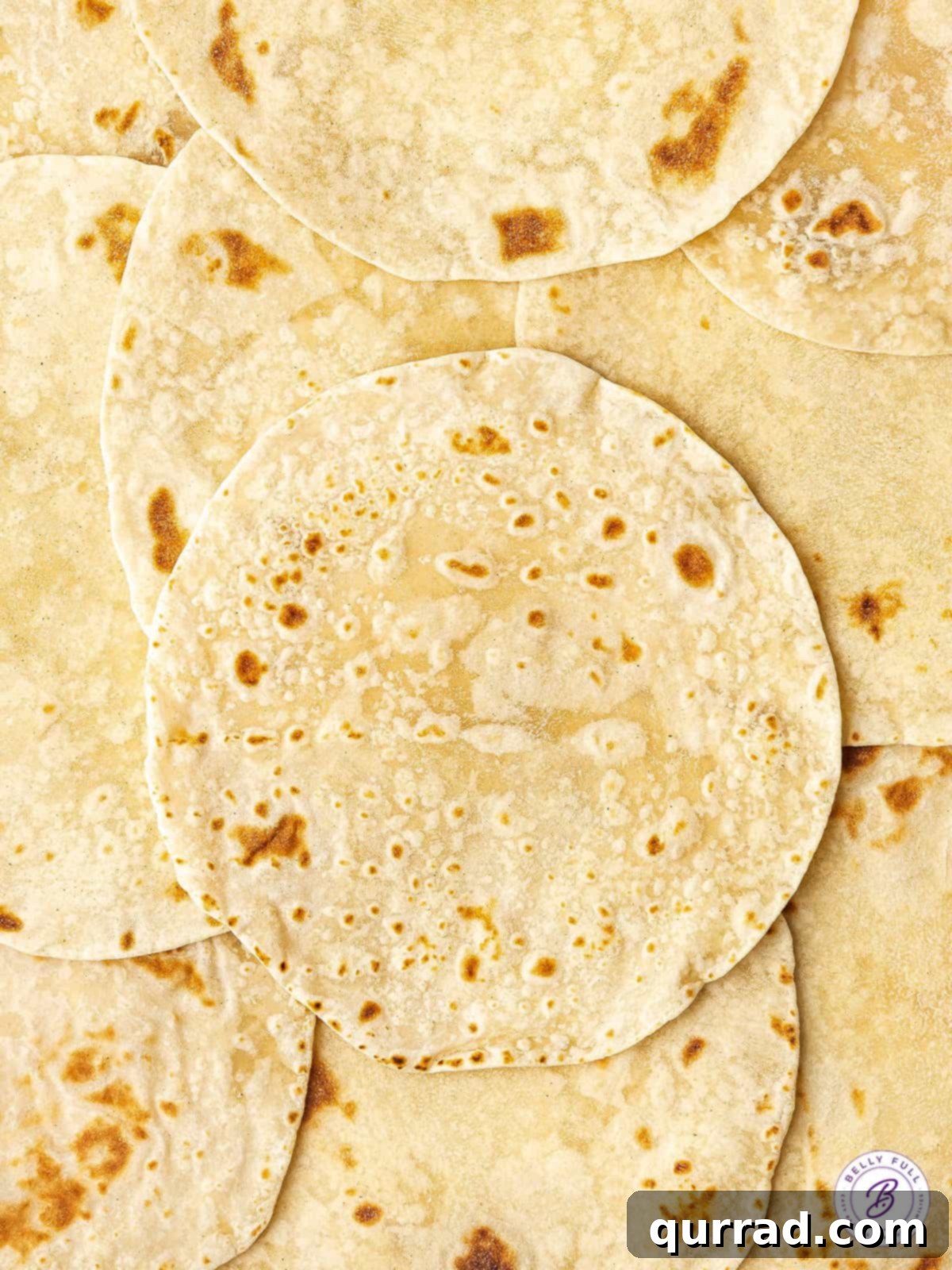 An inviting overhead view of a stack of golden, soft homemade flour tortillas, perfect for any meal.