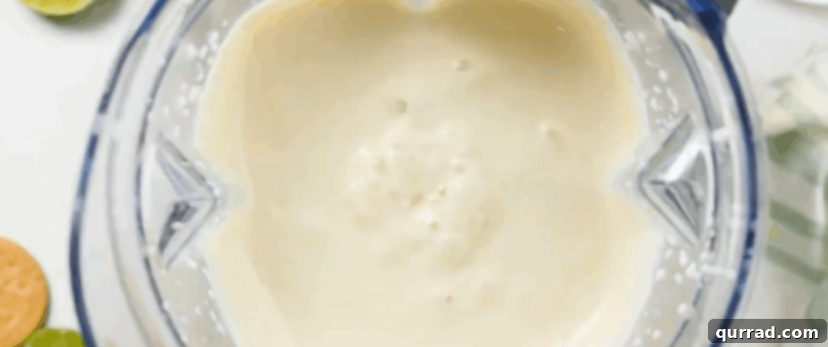Lemon Icebox Cake 4 Lime juice, evaporated milk, and sweetened condensed milk being blended in a blender for the Carlota de Limón filling.