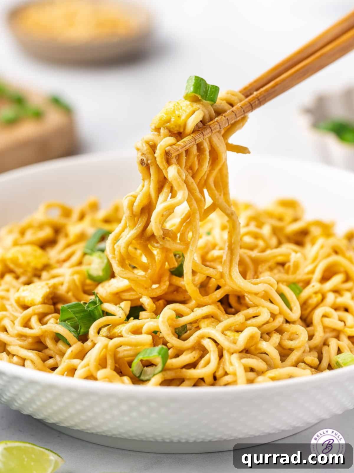 Ramen Pad Thai features inexpensive ramen noodles coated in a simple but flavor-packed peanut sauce. Ready in 10 minutes! Chopsticks holding up some ramen pad thai