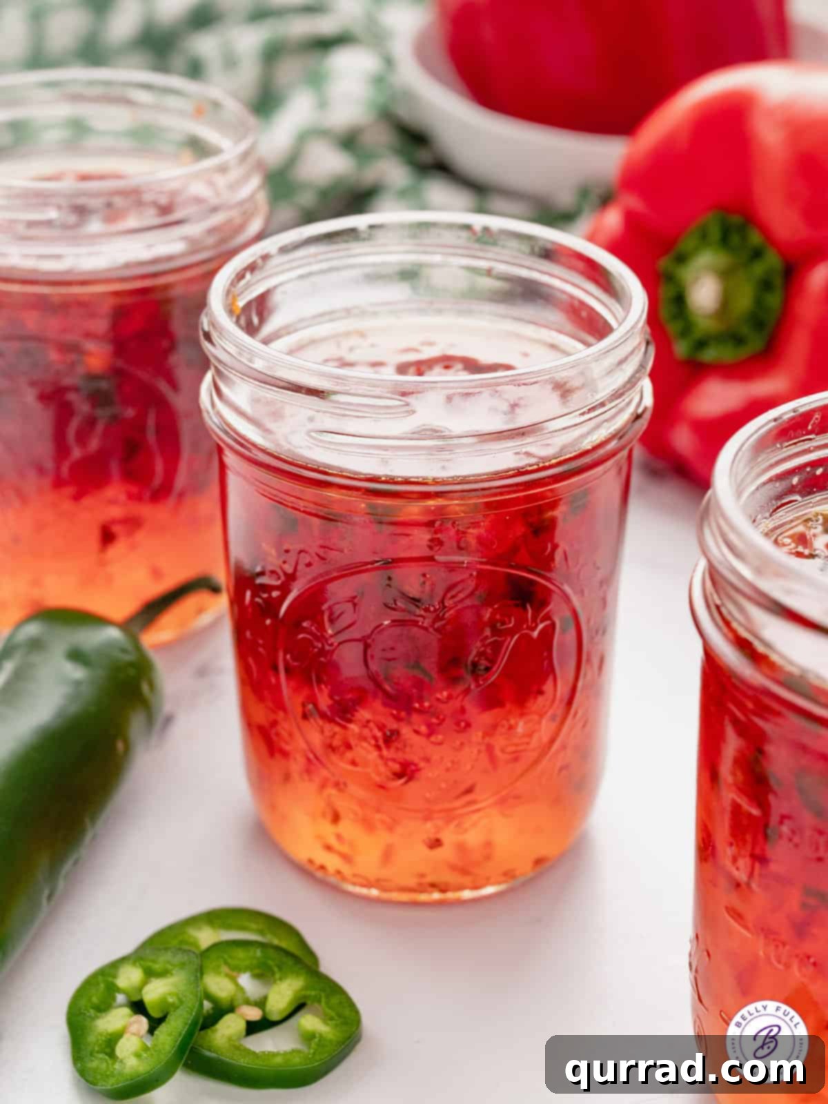 A pint jar of red pepper jelly, ready for storage or gifting.