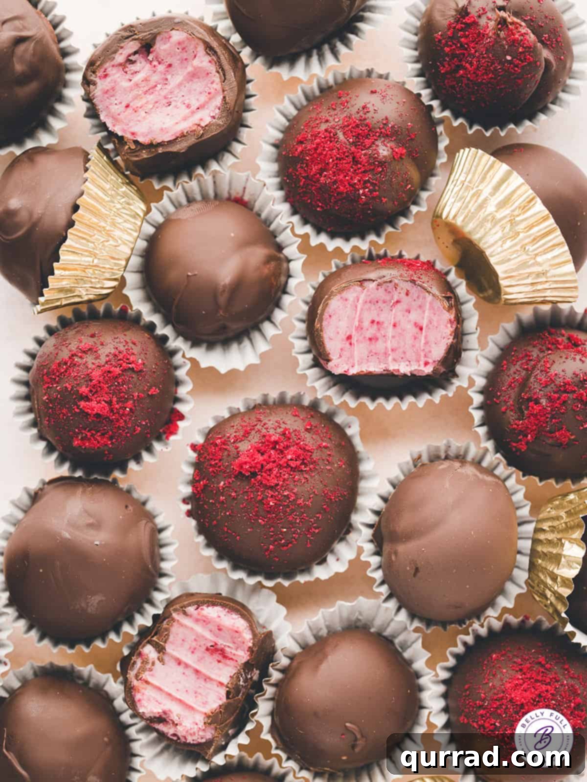 Overhead view of chocolate covered raspberry truffles, some open to show the inside