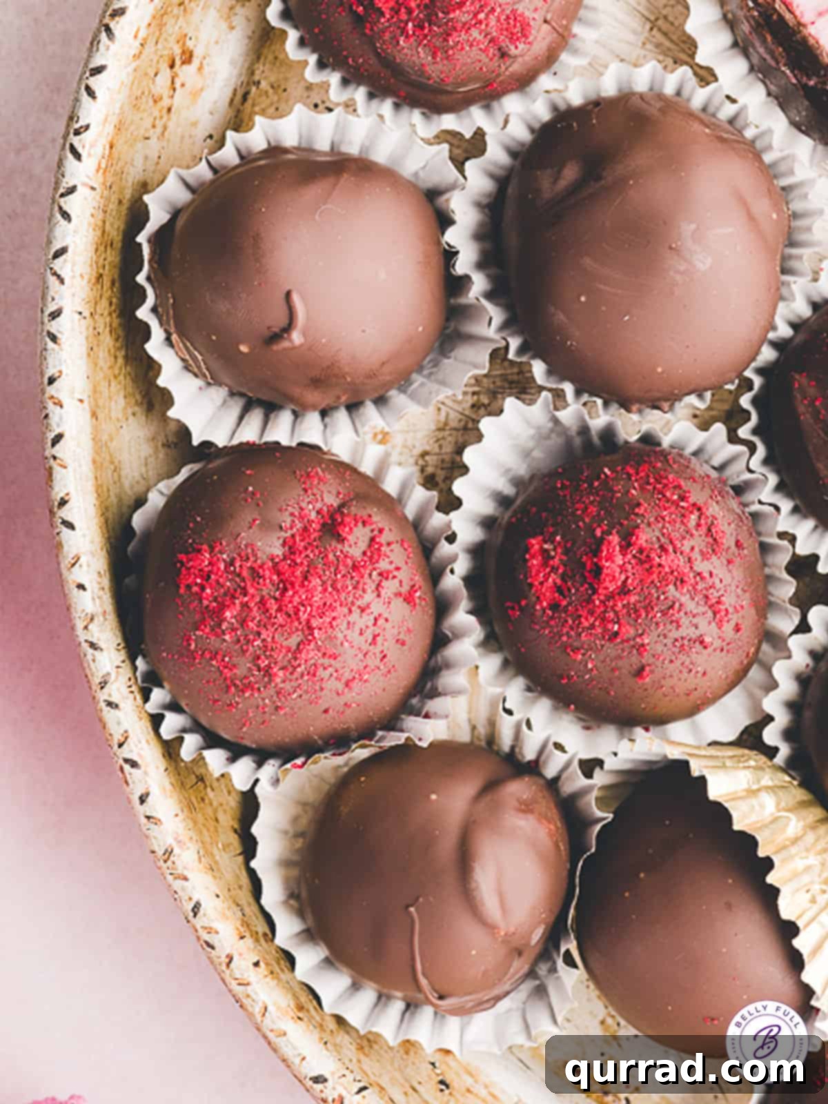Raspberry truffles in candy wrappers on a tray