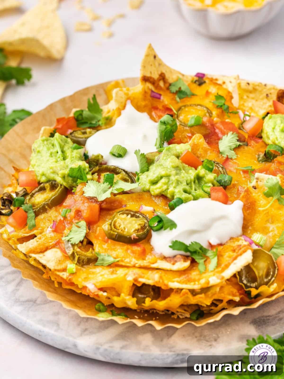 A generous serving of homemade Air Fryer Nachos on a white plate, garnished with fresh cilantro.