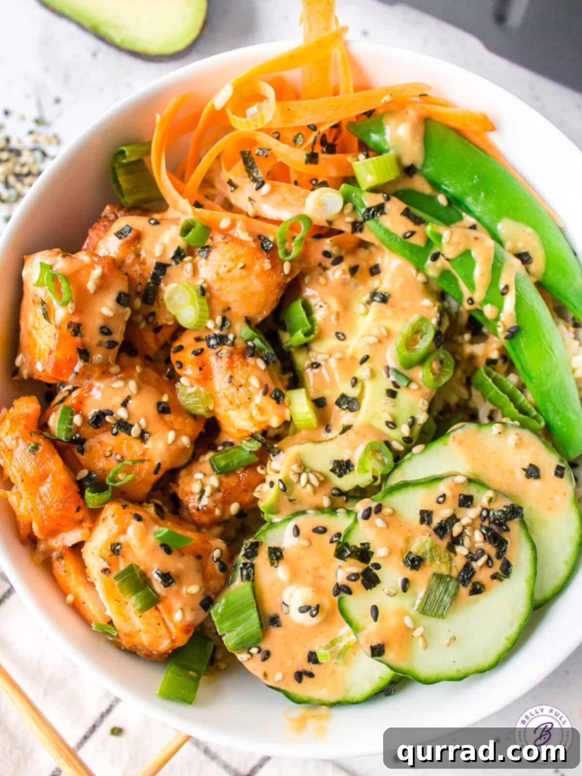 Air Fryer Salmon Bowls: A Healthy & Quick Meal Solution Overhead view of a delicious salmon bowl garnished with fresh cucumbers, shredded carrots, and vibrant snap peas