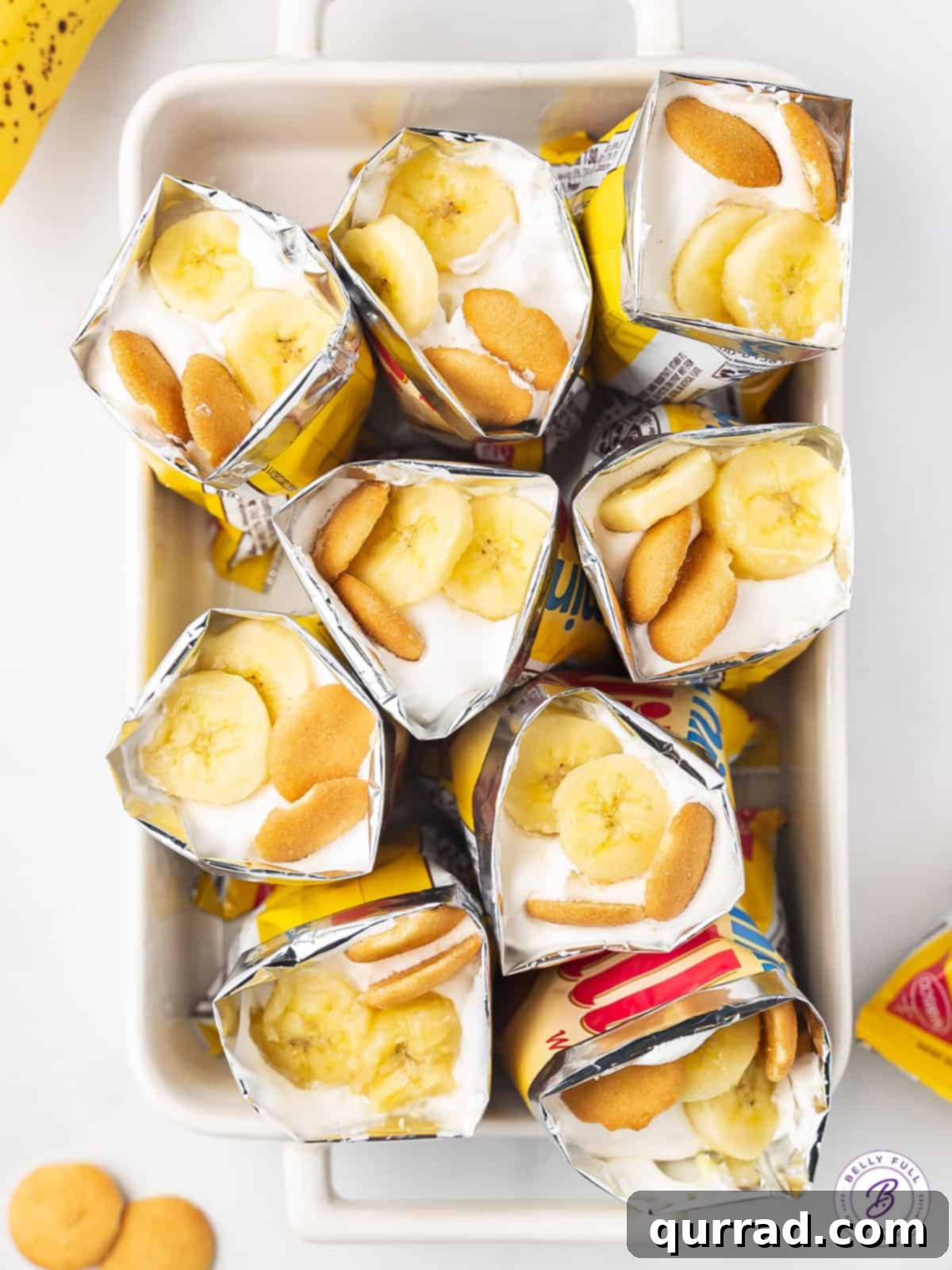 An overhead view of multiple Walking Banana Pudding bags neatly arranged in a baking dish, showcasing the vibrant layers of dessert.