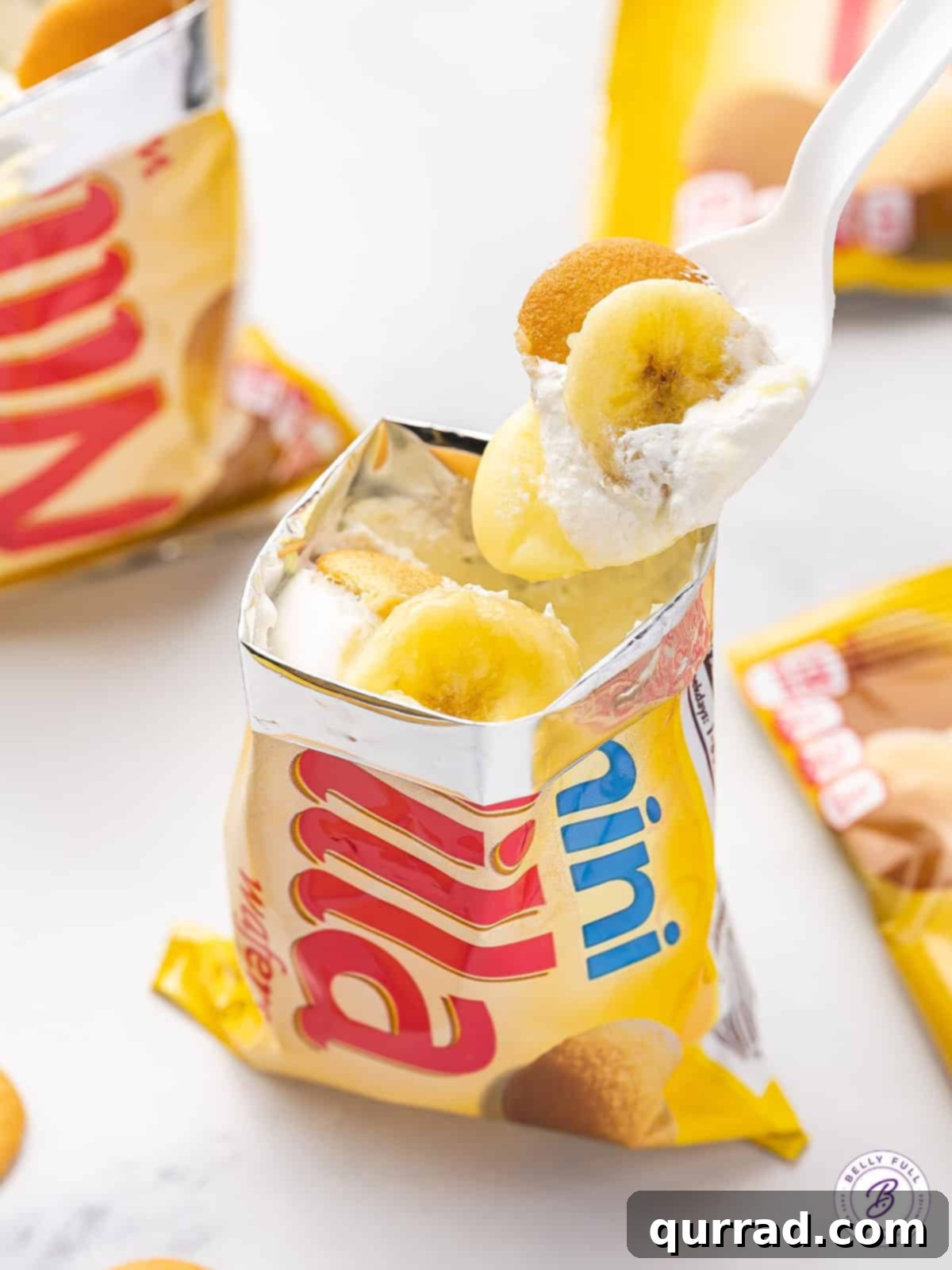 A spoon taking a perfect bite of Walking Banana Pudding, showcasing the delightful layers of banana, pudding, and Nilla wafers.