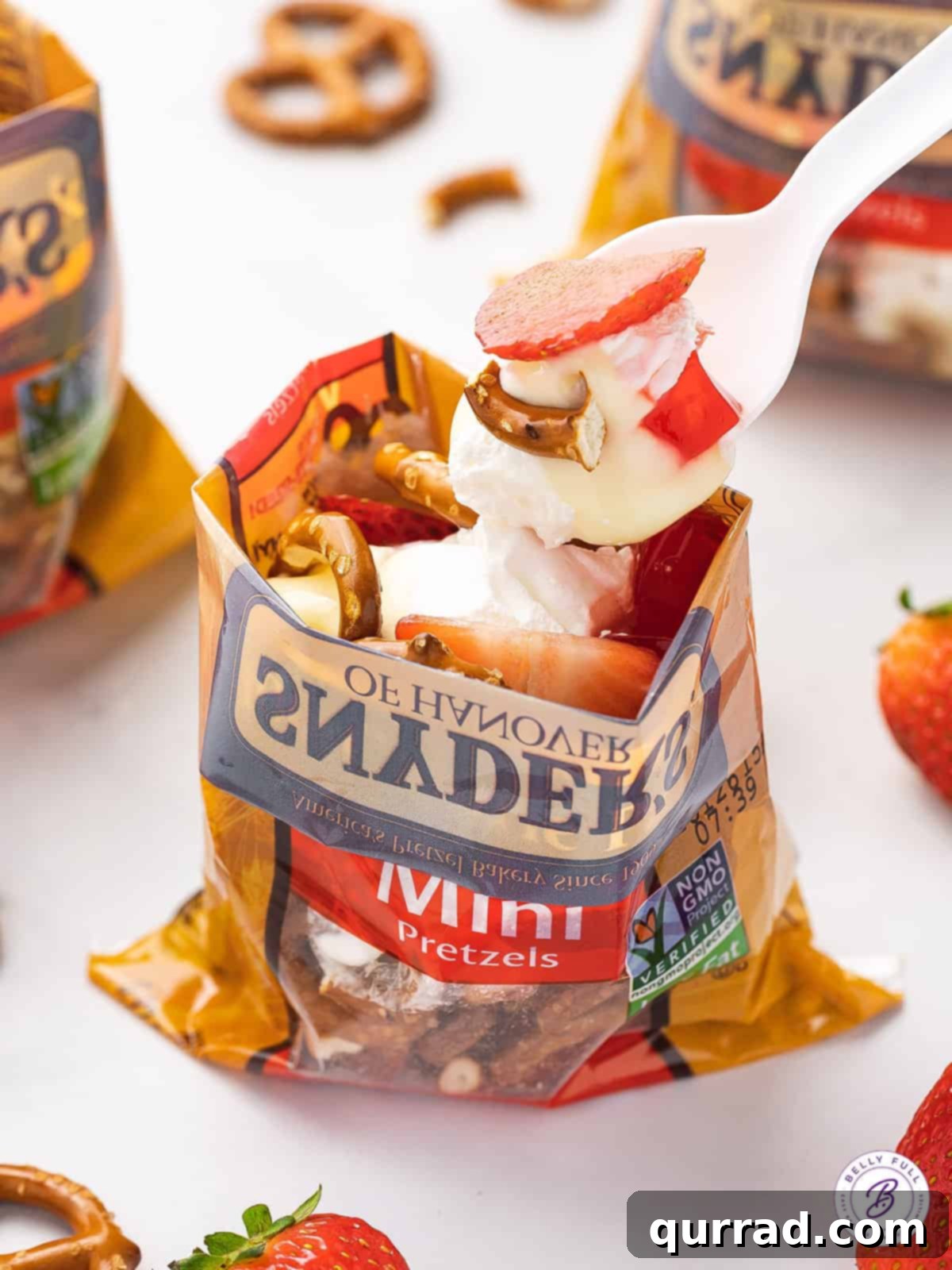 A spoon serving from a walking strawberry pretzel salad