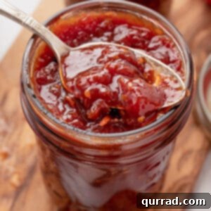 A spoon in a jar of tomato jam
