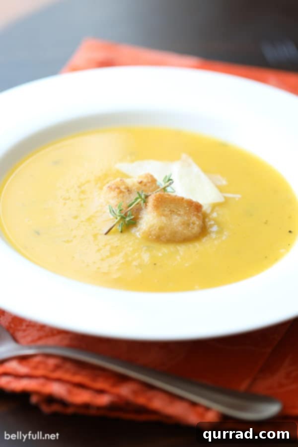 Golden Autumn Butternut Comfort 2 Rich and creamy Roasted Butternut Squash Soup in a white bowl, garnished with fresh herbs.