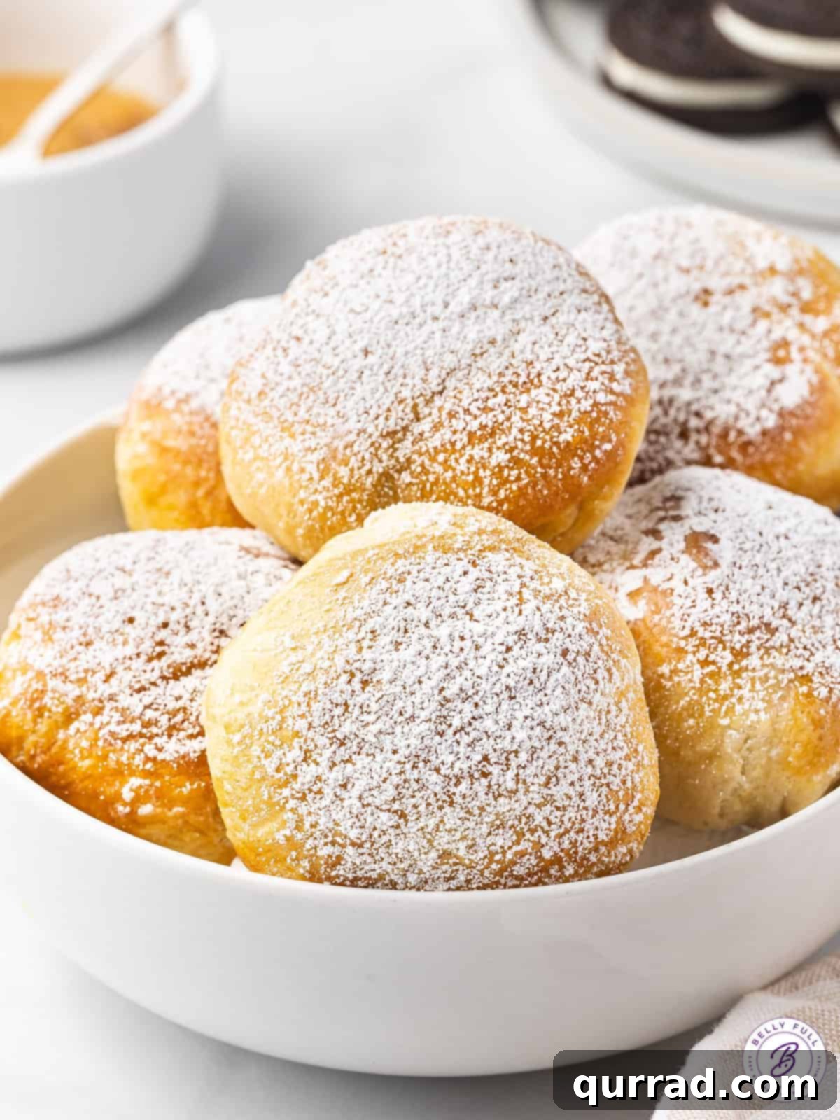 A bowl of air fried Oreos dusted with powdered sugar, ready to be served