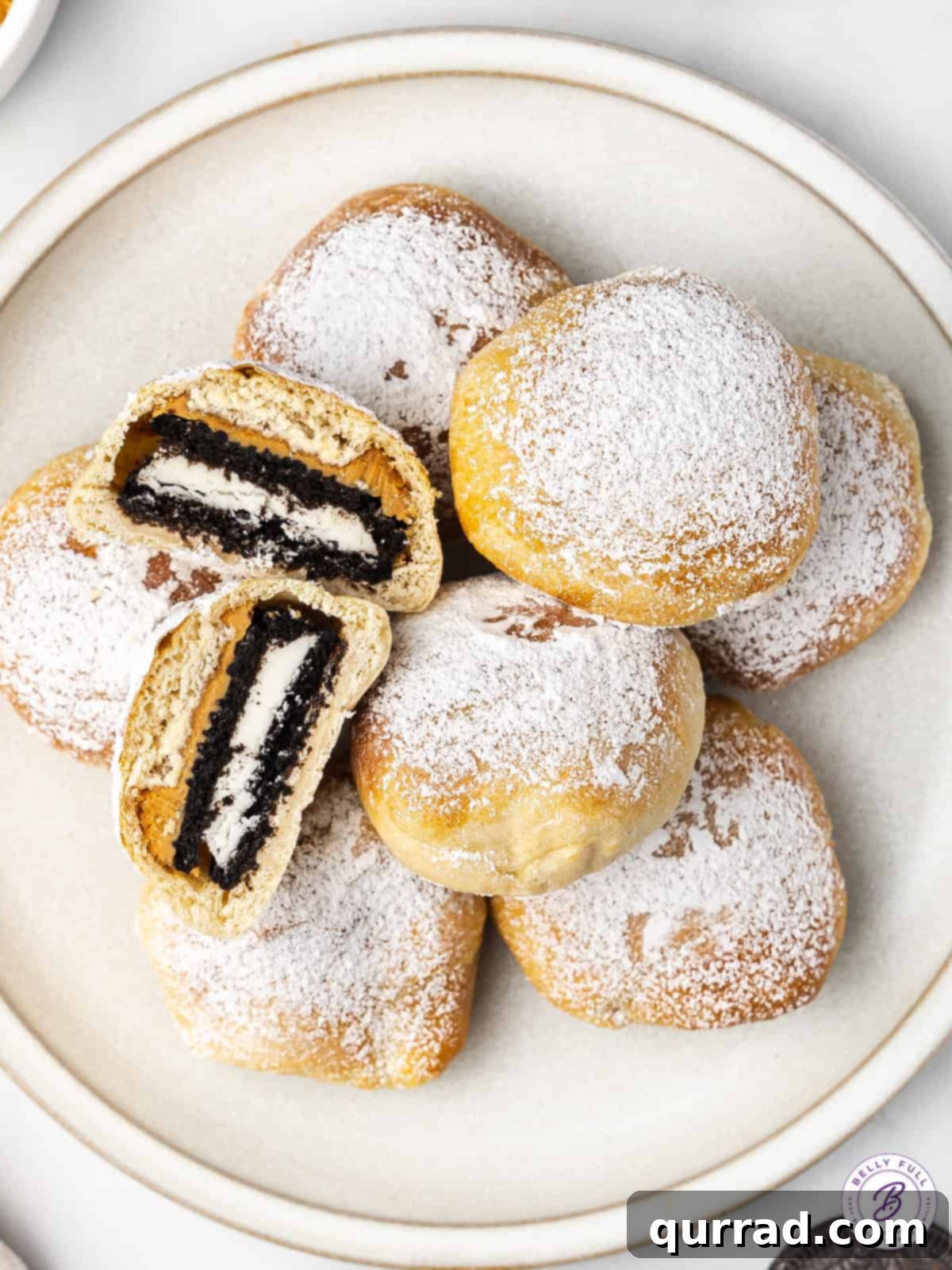 Overhead view of a plate of air fryer Oreos, with one cut in half to show the inside, beautifully presented