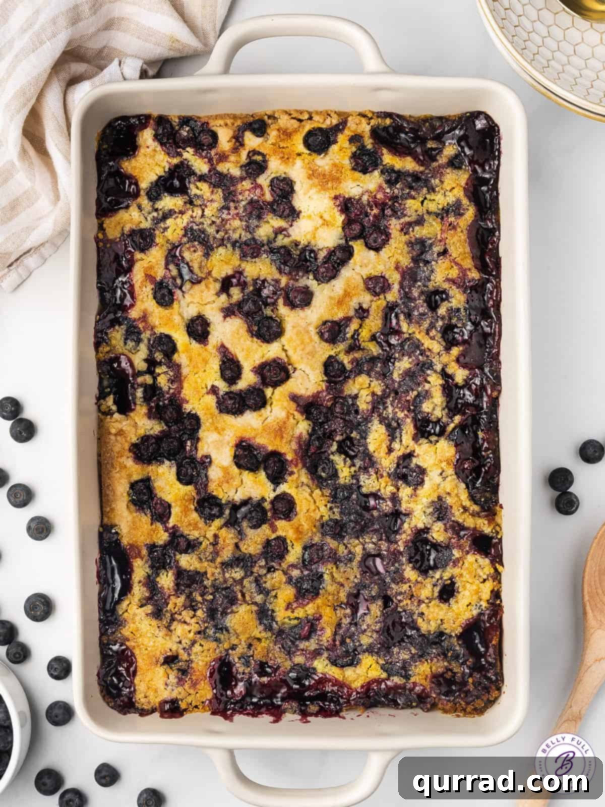 One Pan Blueberry Bliss 8 An overhead view of a perfectly baked blueberry dump cake, golden brown and bubbly in a white 9x13 casserole dish.