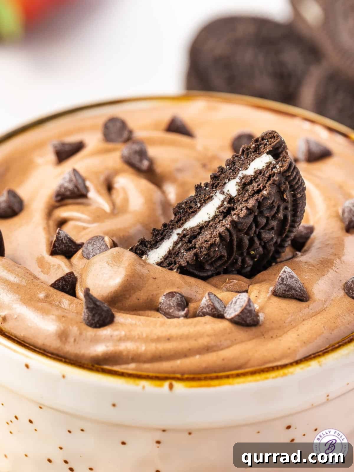 Half of an Oreo in a bowl of brownie dip