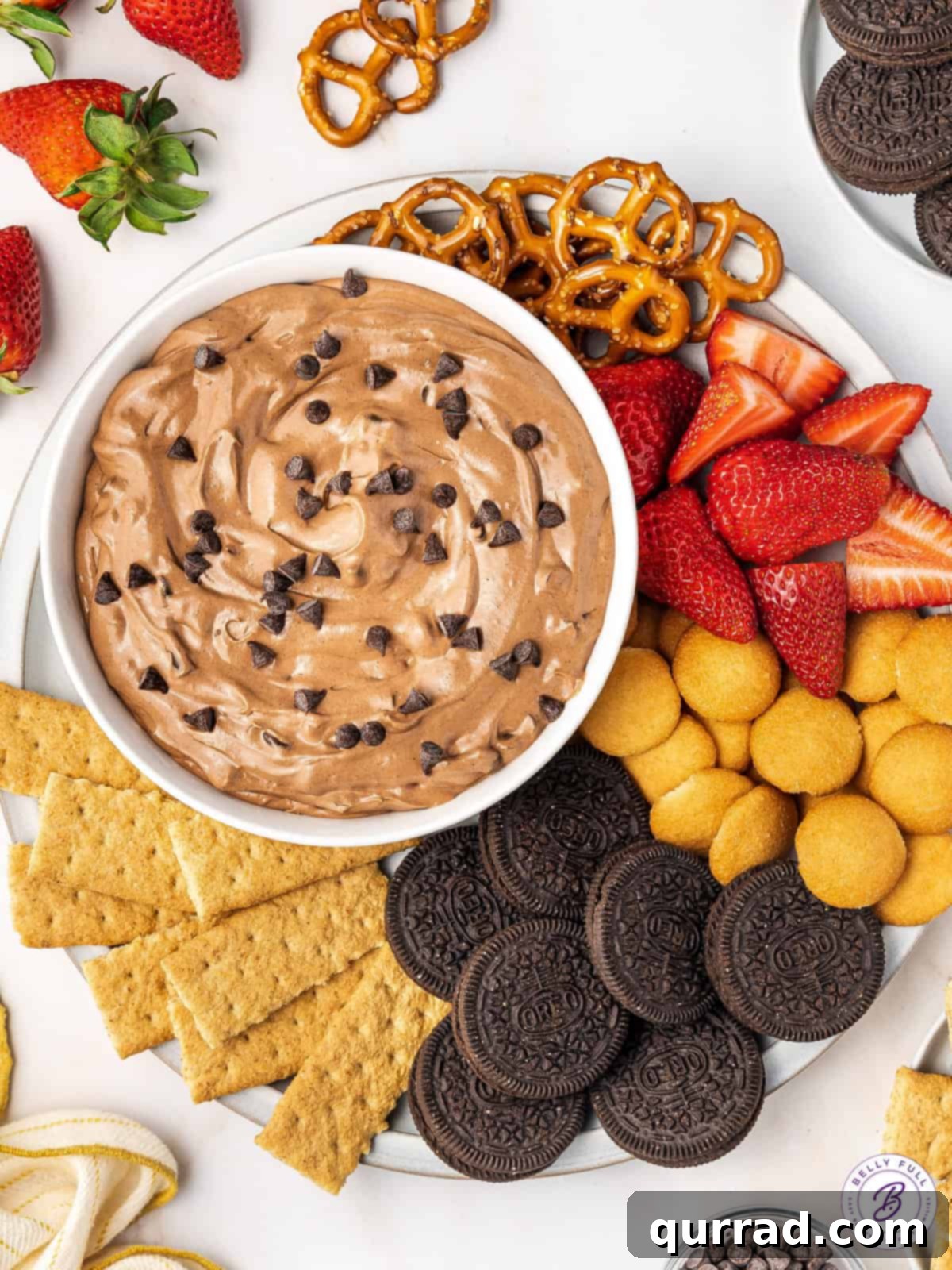A tray with brownie batter dip and various dippers, including graham crackers, Oreos, Nilla Wafers, and strawberries