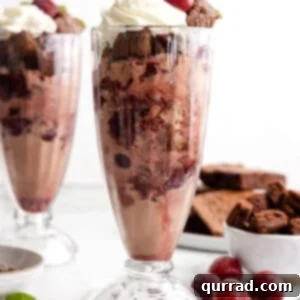 Two black forest ice cream sundaes in tall dishes