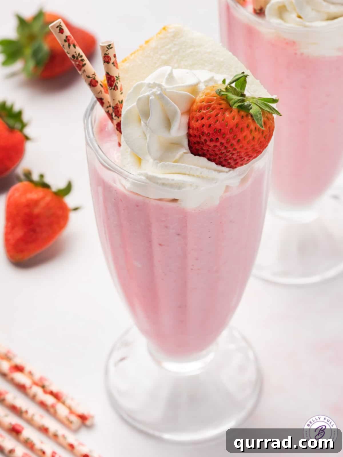 The exquisite Boozy Strawberry Shortcake Milkshake, perfectly presented. An inviting overhead angled view of a beautifully garnished strawberry shortcake milkshake, showing its vibrant color and luxurious toppings.