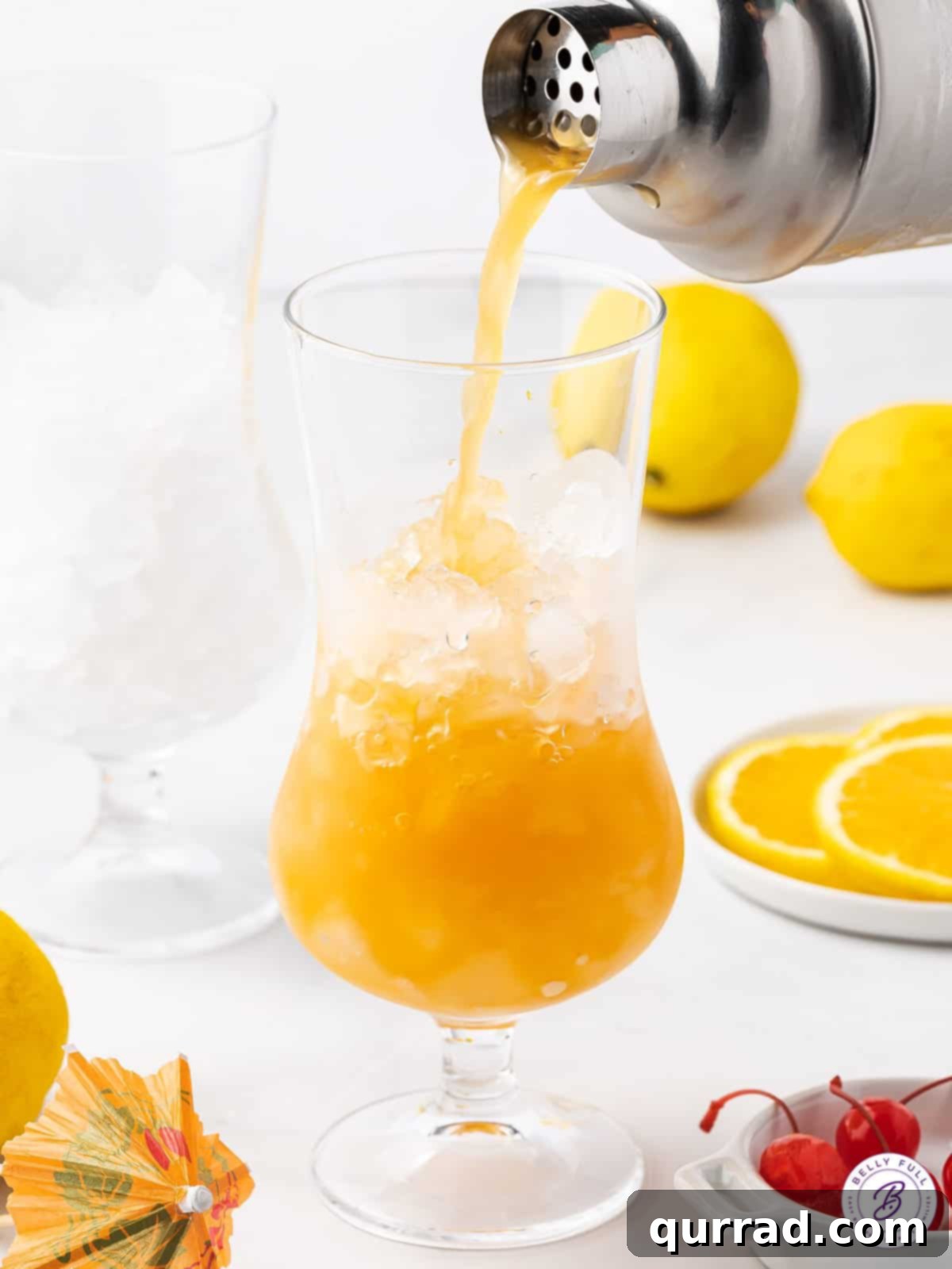 Watch the magic as a Hurricane Drink comes to life, a perfect blend of tropical and strong for your summer enjoyment. A hurricane drink being poured into a glass, highlighting the vibrant red and orange colors.