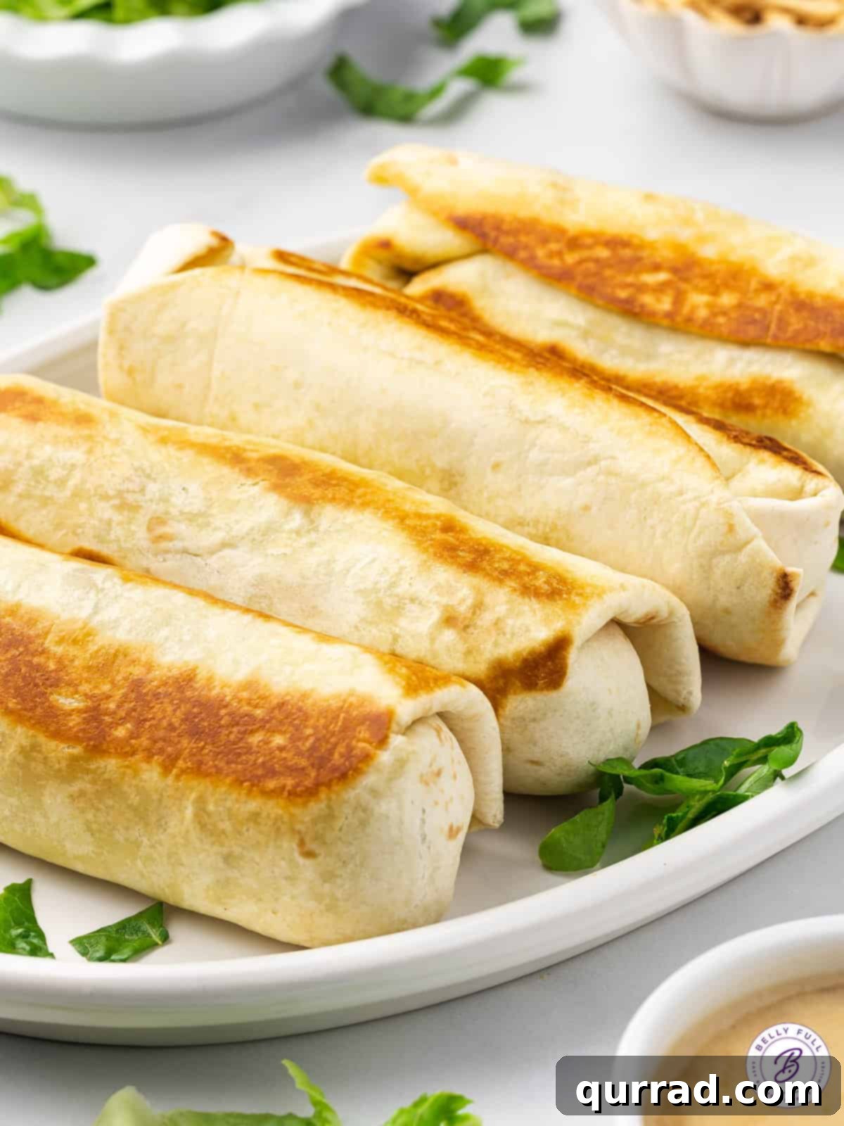 Zesty Asian Chicken Wraps 3 4 toasted burritos on white serving plate