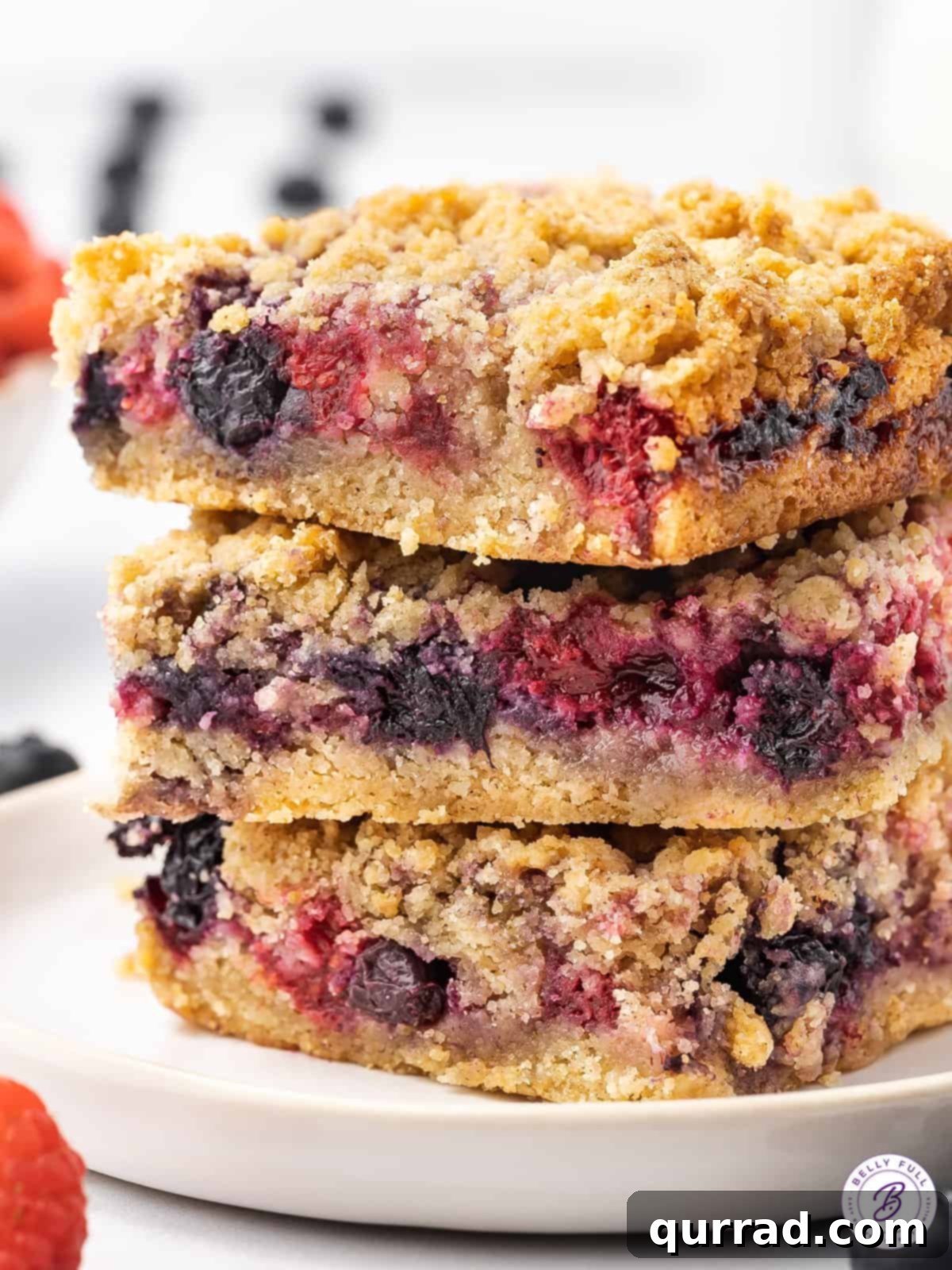 A stack of three berry crumb bars, showcasing their delicious layers