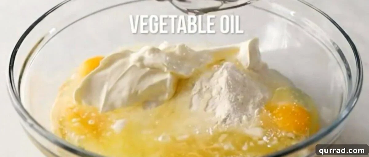 Combining the ingredients to make the cake batter in a glass bowl.