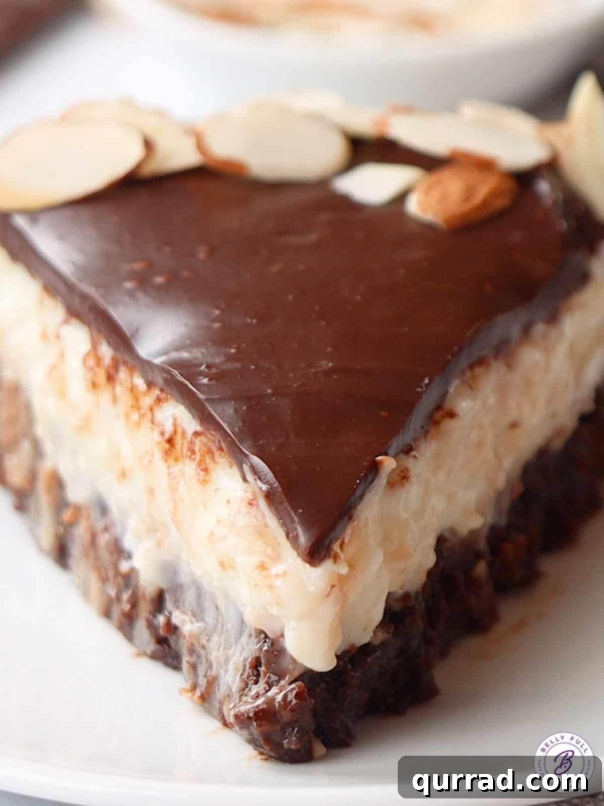 A close-up view of a slice of Almond Joy cake, highlighting the creamy coconut and rich chocolate.