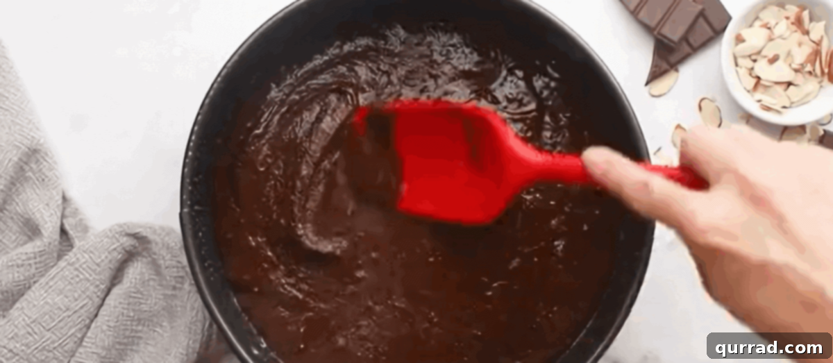 Preparing the rich brownie batter for the base of the Almond Joy cake.