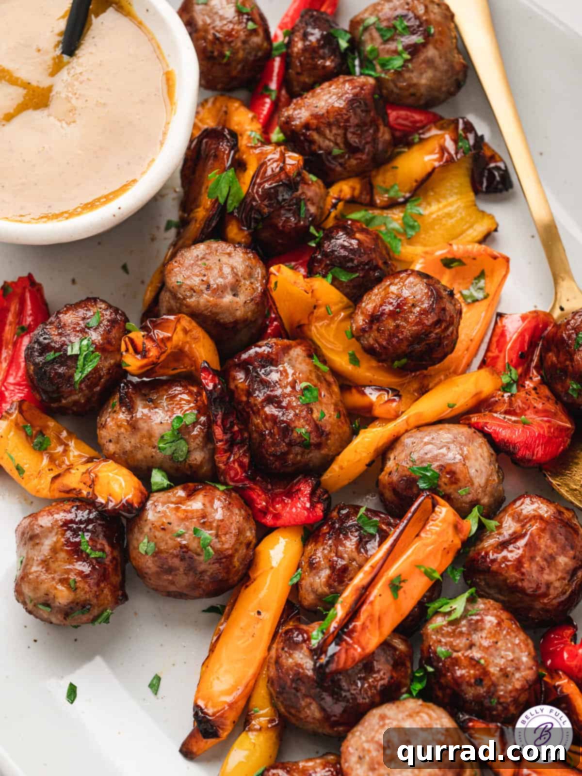 Golden-brown brat bites and vibrant sweet peppers on an elegant platter, ready to be served as an appetizer or meal.