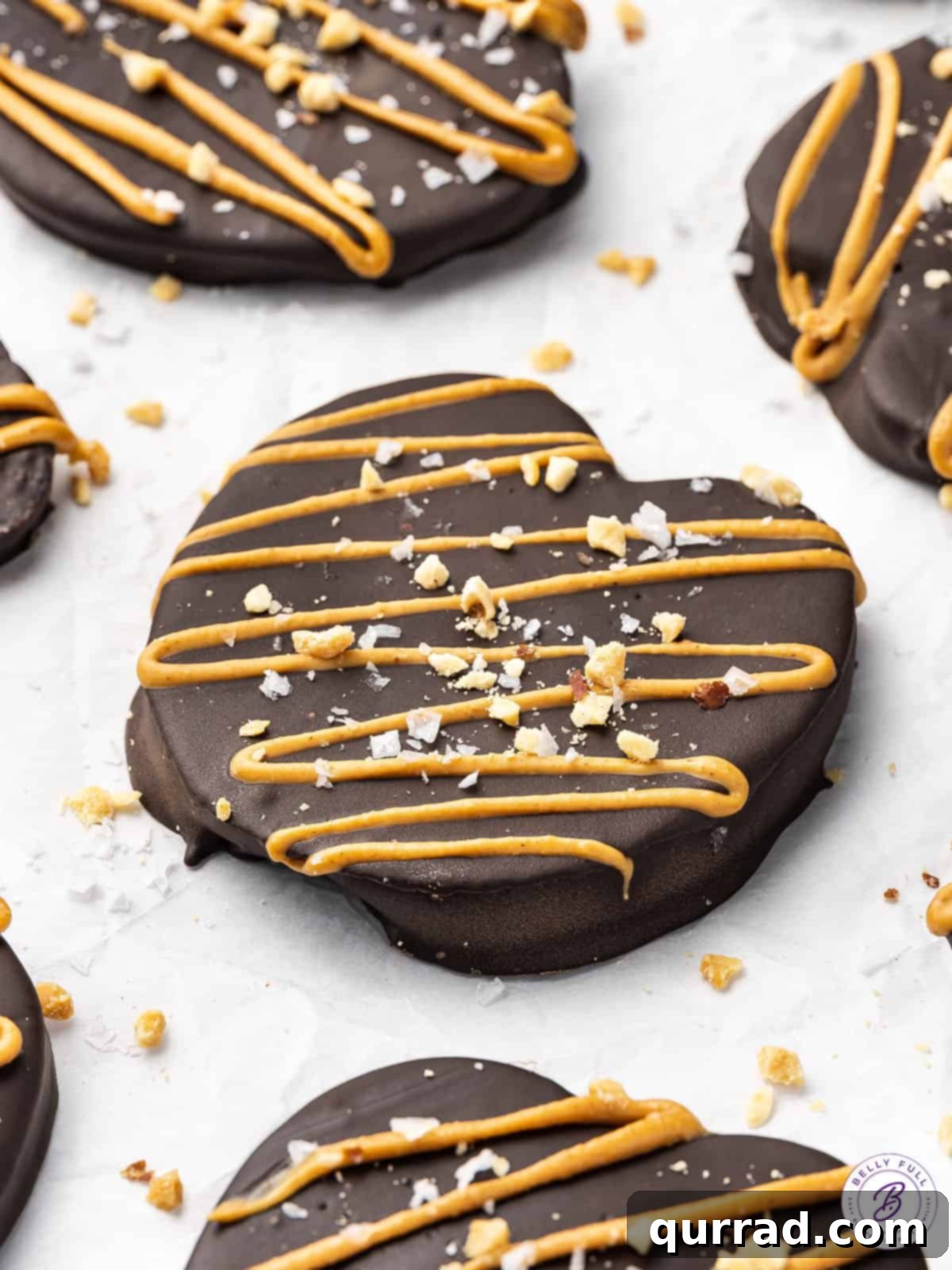 Angled overhead view of chocolate apple slices topped with peanut butter and crushed peanuts