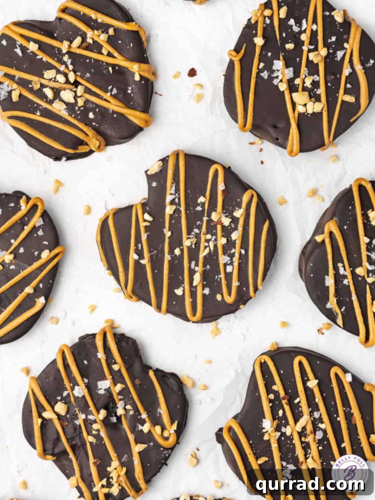 Overhead view of chocolate covered apple slices on a baking sheet, with various toppings