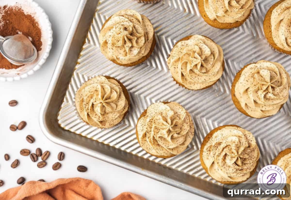 An overhead view of a tray of freshly baked coffee cupcakes with rich coffee buttercream, neatly arranged.