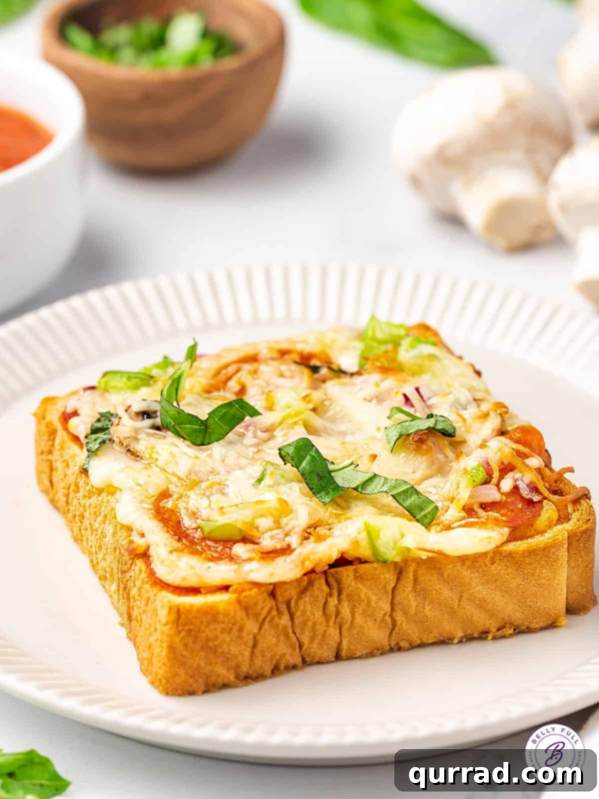 Quick & Easy Texas Toast Pizza for Busy Nights Angled view of a golden-brown slice of Texas Toast pizza on a white plate, showcasing melted cheese and vibrant toppings.