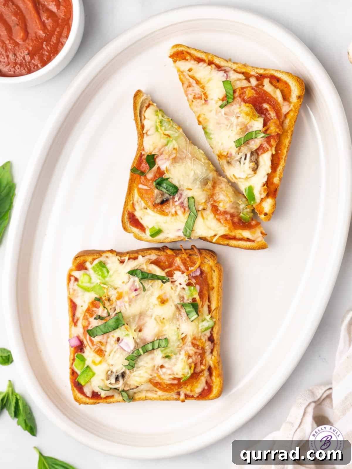 Serving Up Delightful Pizza Toast Two perfectly baked slices of Texas Toast pizza, golden and bubbly, presented on an elegant platter.