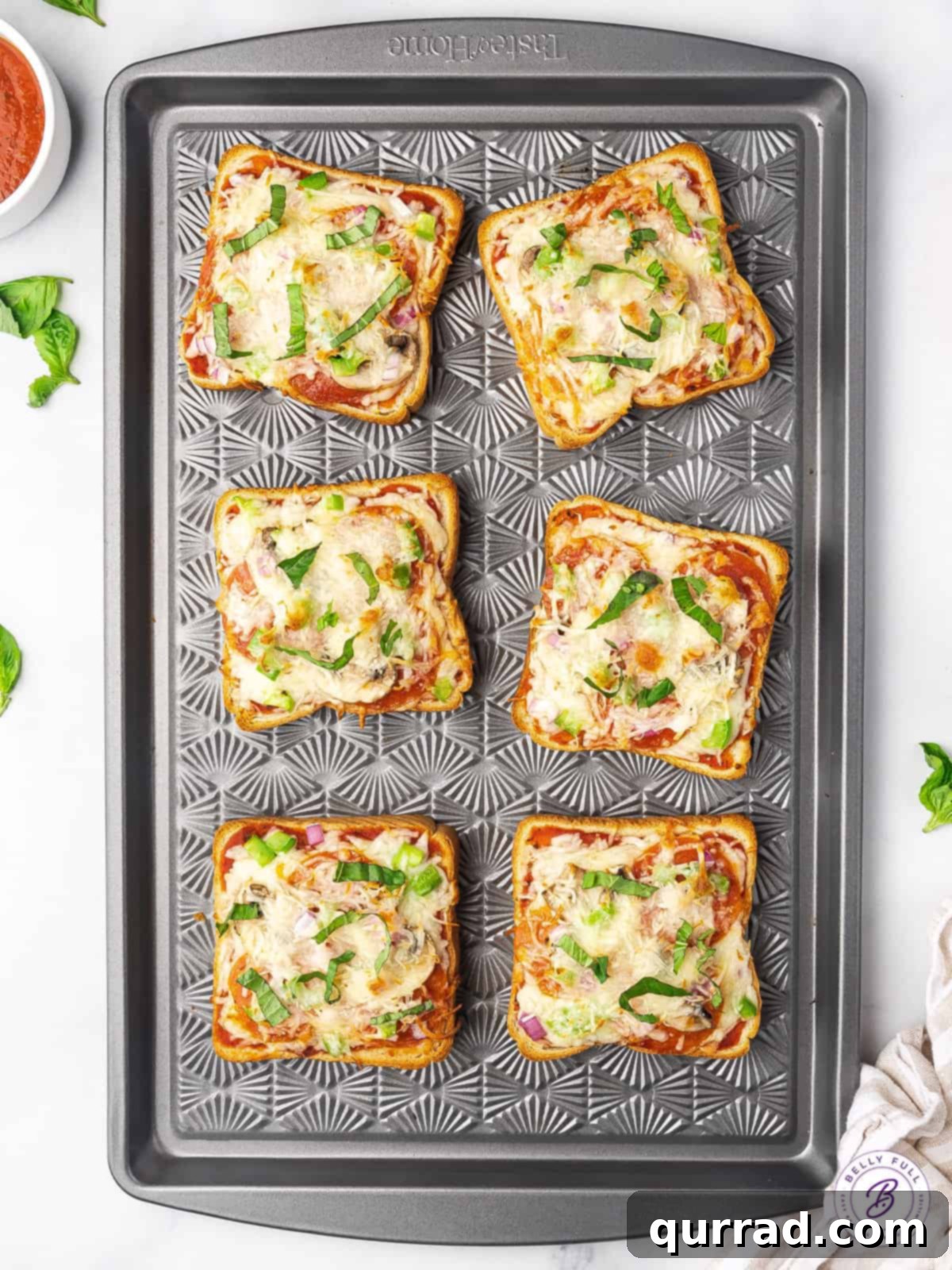 Batch of Freshly Baked Pizza Toast Six perfectly baked Texas Toast pizza slices arranged neatly on a baking sheet, ready to be served.