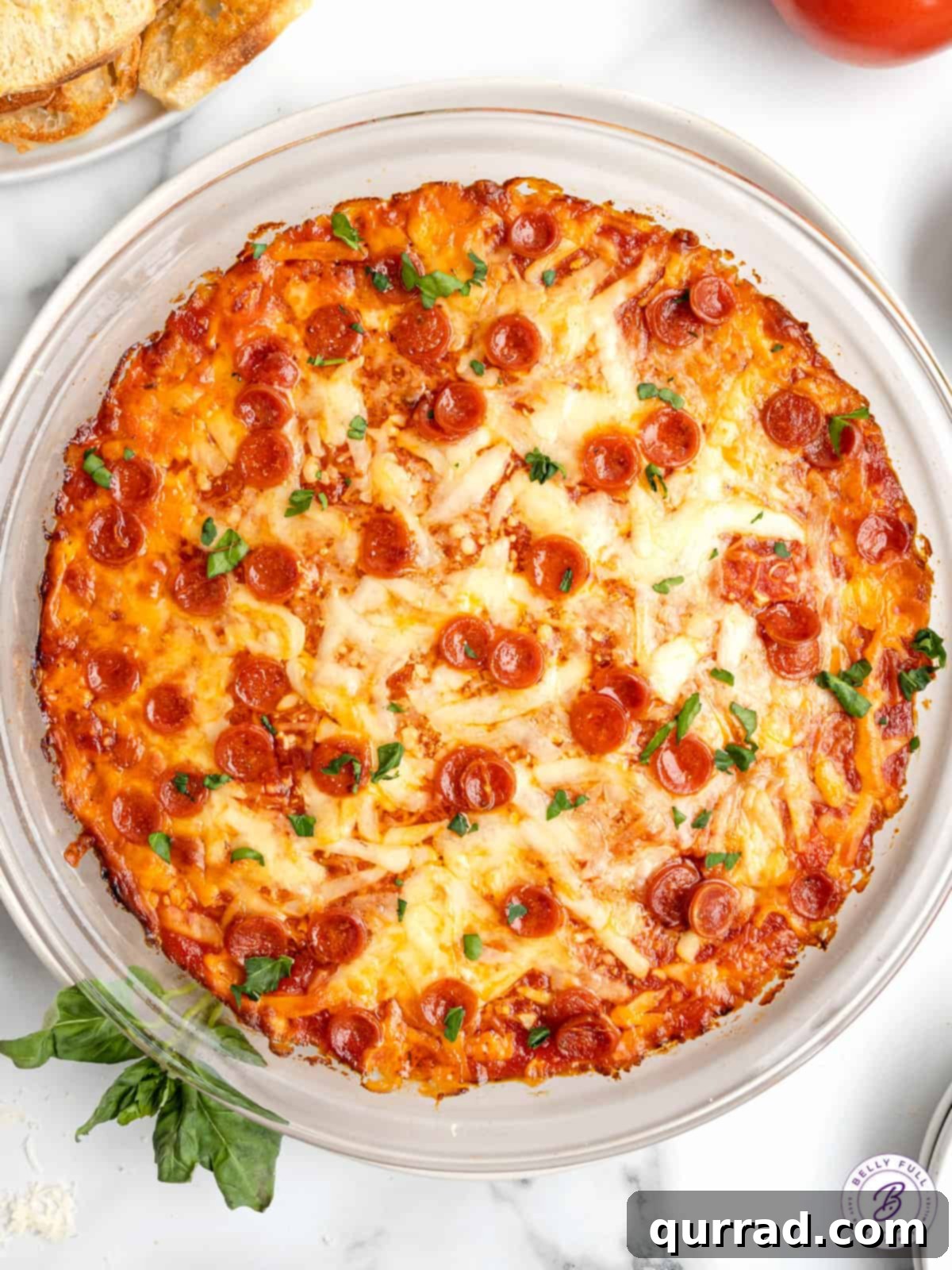 Made with just 5 ingredients (three of which are cheese!), this Pizza Dip is a party appetizer everyone will enjoy! Easy & cheesy! Overhead view of a round dish of bubbly, golden-brown pizza dip topped with mini pepperonis