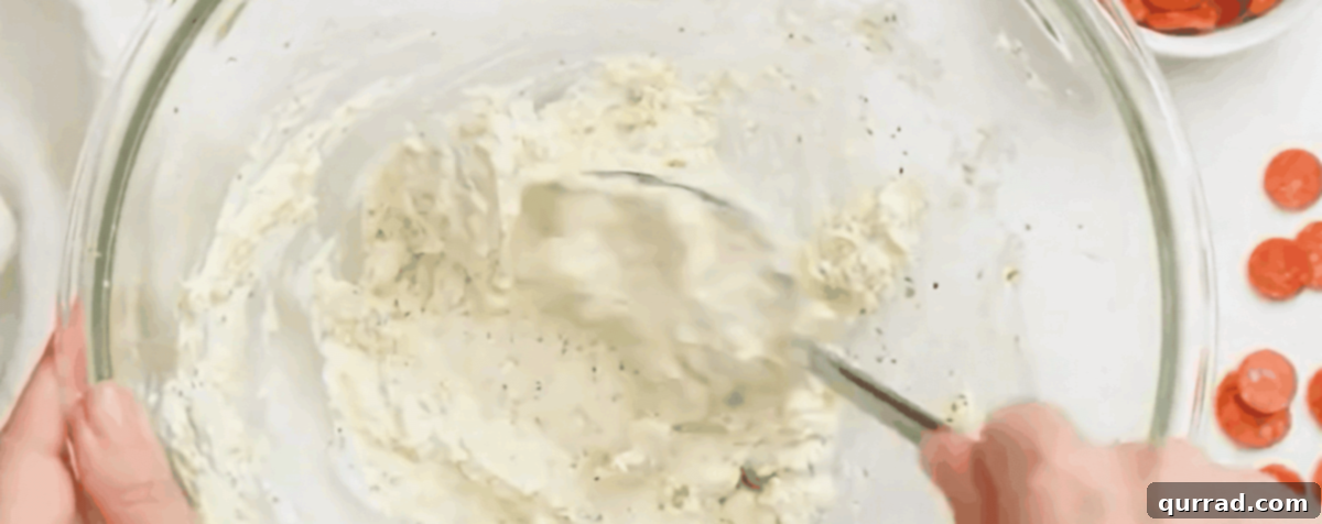 Hot Pizza Dip 3 Combining the cream cheese, mozzarella, parmesan, and seasonings for the base layer of the pizza dip.
