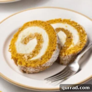 Two slices of pumpkin roll on a plate, showcasing the elegant spiral.